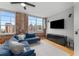 Bright living room featuring exposed brick, large windows with cityscape view, and a comfortable blue couch at 800 Peachtree Ne St # 8612, Atlanta, GA 30308