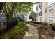 Lush walkway along the building with a manicured lawn and mature trees for residents and their pets to enjoy at 800 Peachtree Ne St # 8612, Atlanta, GA 30308
