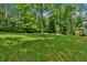 Exterior view of home with back yard featuring spacious manicured lawn and mature trees at 323 Bells Ferry Ne Rd, White, GA 30184