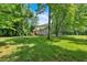 Exterior view of home from back yard featuring spacious yard and mature trees at 323 Bells Ferry Ne Rd, White, GA 30184