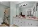 Bright bathroom featuring a double vanity, large mirror, and a shower-tub combo at 323 Bells Ferry Ne Rd, White, GA 30184