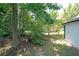 Lush backyard featuring mature trees, green grass and a partial view of the home's exterior at 3087 Drexel Ln, Jonesboro, GA 30236