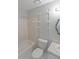 Functional bathroom featuring a white toilet, tub, and vanity area with wall storage shelves and large mirror at 3087 Drexel Ln, Jonesboro, GA 30236