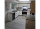 Bright kitchen with granite countertops, stainless steel appliances, and light gray wood flooring at 3087 Drexel Ln, Jonesboro, GA 30236