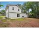 Spacious backyard with a well-maintained lawn, a concrete patio, and a charming white brick house at 4148 Emerald North Dr, Decatur, GA 30035