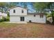Expansive backyard with a well-maintained lawn, a concrete patio, and a charming white brick house at 4148 Emerald North Dr, Decatur, GA 30035