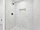 Modern bathroom with an eye-catching white marble design on the wall and floor tiles, black trim, and stylish fixtures at 4148 Emerald North Dr, Decatur, GA 30035