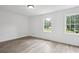 Bright bedroom featuring light hardwood floors and two windows providing natural light at 4148 Emerald North Dr, Decatur, GA 30035