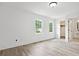 Spacious bedroom featuring light hardwood floors, an ensuite bathroom, and two windows at 4148 Emerald North Dr, Decatur, GA 30035