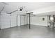 Spacious three-car garage featuring smooth concrete floors and ample storage space, illuminated by overhead lighting at 4148 Emerald North Dr, Decatur, GA 30035