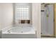 Bathroom features a soaking tub, glass block window, and separate shower at 1452 Evanston Ln, Marietta, GA 30062
