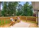 A charming wood deck features chairs, a table, and a beautiful backyard view at 2090 Rocky Mill Drive, Lawrenceville, GA 30044