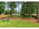 A spacious backyard featuring a large lawn, mature trees, and a wood fence at 2090 Rocky Mill Drive, Lawrenceville, GA 30044