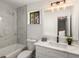 Contemporary bathroom featuring stylish mirror and light fixture, sink, and a tub with marble tiling at 2090 Rocky Mill Drive, Lawrenceville, GA 30044