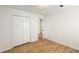 A bright bedroom featuring wood floors, a closet, and an open door to the hallway at 2090 Rocky Mill Drive, Lawrenceville, GA 30044