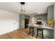 Well-lit kitchen with light green cabinets, stainless steel appliances, and a stylish breakfast bar with barstools at 2090 Rocky Mill Drive, Lawrenceville, GA 30044