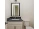 Neutral-toned half bathroom with black framed mirror, dark countertop, and contemporary fixtures at 38 Mildred Nw Pl, Atlanta, GA 30318