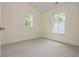Empty bedroom showcasing two windows that provide ample natural light and cozy carpet flooring at 38 Mildred Nw Pl, Atlanta, GA 30318