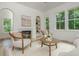 Cozy living room with a fireplace, built-in shelving, and large windows overlooking a wooded yard at 38 Mildred Nw Pl, Atlanta, GA 30318