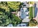 Aerial view of lush backyard featuring a stone patio, fire pit, mature landscaping, and wooded border at 660 Briarleigh Way, Woodstock, GA 30189