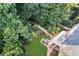 Aerial view of a private backyard oasis with mature trees, lush landscaping, stone path, and fire pit area at 660 Briarleigh Way, Woodstock, GA 30189