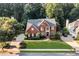 Beautiful brick home with manicured front lawn, lush landscaping and mature trees at 660 Briarleigh Way, Woodstock, GA 30189