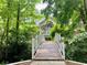 Beautiful home exterior featuring a quaint bridge amidst lush greenery, providing serene access at 660 Briarleigh Way, Woodstock, GA 30189