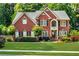 Charming brick home featuring lush landscaping, a manicured lawn, and a welcoming front entrance at 660 Briarleigh Way, Woodstock, GA 30189