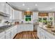 Bright kitchen features white cabinets, granite countertops, and modern appliances at 660 Briarleigh Way, Woodstock, GA 30189