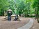 Charming playground with modern play equipment nestled among mature trees in the community at 660 Briarleigh Way, Woodstock, GA 30189