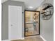 Modern tile shower with glass doors, shelving niche, and door leading to bathroom at 660 Briarleigh Way, Woodstock, GA 30189