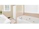 Bright bathroom with a soaking tub and shower with natural light from the window at 1574 Glenfield Dr, Lawrenceville, GA 30043