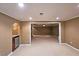 Open basement area features an arched entrance to a wet bar with a mini refrigerator and granite counter at 1620 Silverleaf Way, Alpharetta, GA 30005