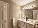 Neutral bathroom with double sink vanity, towel racks, and a large mirror with Hollywood-style lighting at 1620 Silverleaf Way, Alpharetta, GA 30005