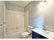 Clean bathroom featuring a tub and shower, a toilet, a white sink, and a navy blue cabinet at 1620 Silverleaf Way, Alpharetta, GA 30005
