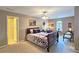 Well-lit bedroom with ceiling fan, neutral walls, and carpet; chairs and a queen bed with floral-patterned bedding at 1620 Silverleaf Way, Alpharetta, GA 30005