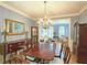 Dining room with a chandelier, hardwood floors, a large table with seating for six, and a view into the living room at 1620 Silverleaf Way, Alpharetta, GA 30005