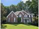 Charming two-story brick home with black shutters, white trim, lush landscaping, and a well-manicured lawn at 1620 Silverleaf Way, Alpharetta, GA 30005