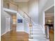 Foyer featuring a carpet staircase with oak banister and hardwood floors, leading to upper level and bedrooms at 1620 Silverleaf Way, Alpharetta, GA 30005