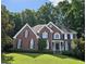 Beautiful two-story brick home featuring manicured lawn and mature trees at 1620 Silverleaf Way, Alpharetta, GA 30005