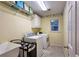 Practical laundry room with washer, dryer, utility sink, storage shelves and a small window at 1620 Silverleaf Way, Alpharetta, GA 30005