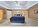Bright main bedroom with a large bed, tray ceilings, neutral walls and plush carpeting at 1620 Silverleaf Way, Alpharetta, GA 30005