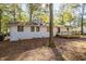 Back exterior of a home featuring a new wooden deck, a painted brick facade, and black framed windows at 409 Colette Ln, Social Circle, GA 30025