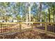 Outdoor wooden deck image surrounded by trees in a lush green landscape with natural lighting at 409 Colette Ln, Social Circle, GA 30025