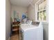 Laundry room with modern washer and dryer units and shelves for storage and organization at 409 Colette Ln, Social Circle, GA 30025