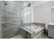 Modern bathroom featuring a glass-enclosed shower and tub with stylish gray tile surround at 1049 Brandsford Nw St # 27-01, Atlanta, GA 30318