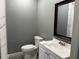 Bathroom with a white vanity, commode, and a shower with glass doors at 2181 Rodao Sw Dr, Lilburn, GA 30047