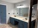 Bathroom vanity with double sinks, cabinets, a large mirror, and updated fixtures at 2181 Rodao Sw Dr, Lilburn, GA 30047