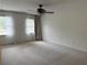 Spacious carpeted bedroom with a ceiling fan and bright natural light from the window at 2181 Rodao Sw Dr, Lilburn, GA 30047