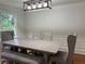 Bright dining room featuring a wooden table, gray chairs, and a modern light fixture at 2181 Rodao Sw Dr, Lilburn, GA 30047